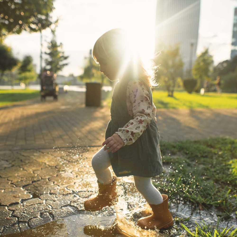 Child playing in puddle at park near The Carlton At Lake Dexter in Winter Haven, Florida