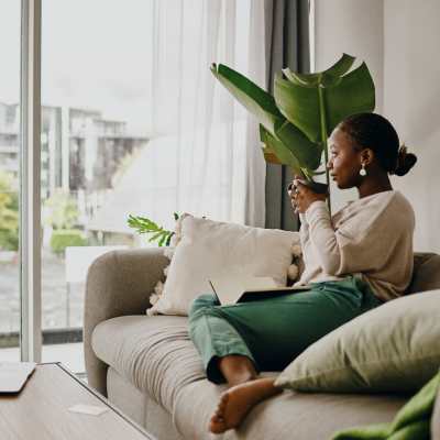 Resident having a cup of coffee while admiring the neighborhood while sitting on a couch at Verde Vue, Savannah, Georgia
