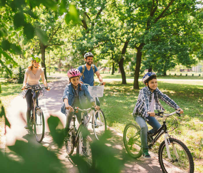 Family on bicycles in a park near Commons At Westchase in Houston, Texas