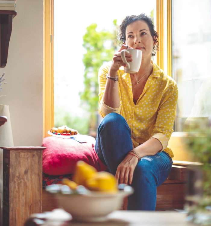 Woman drinking coffee in her kitchen at Vintage at Redfield in Reno, Nevada