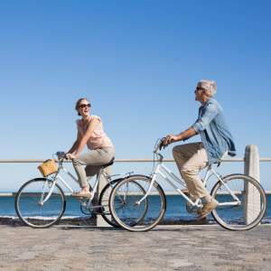 Two individuals cycling along a sandy beach near EVOQ East Cobb in Marietta, Georgia
