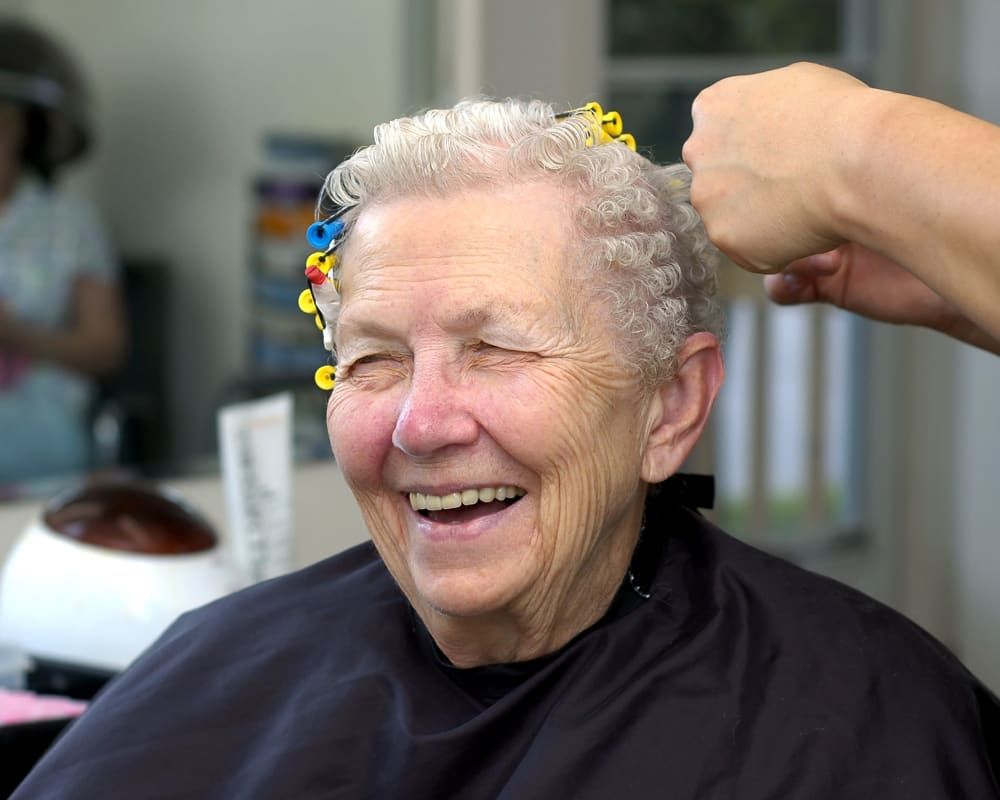 A resident having her hair curled at Welbrook Grand Montecito in Las Vegas, Nevada