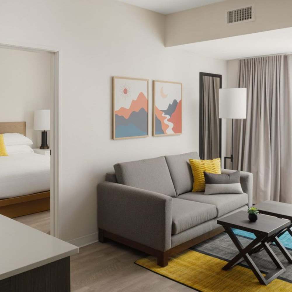 Modern living room with gray sofa, decorative pillows, artwork, and wood-style flooring at WaterWalk Boise - Meridian in Meridian, Idaho