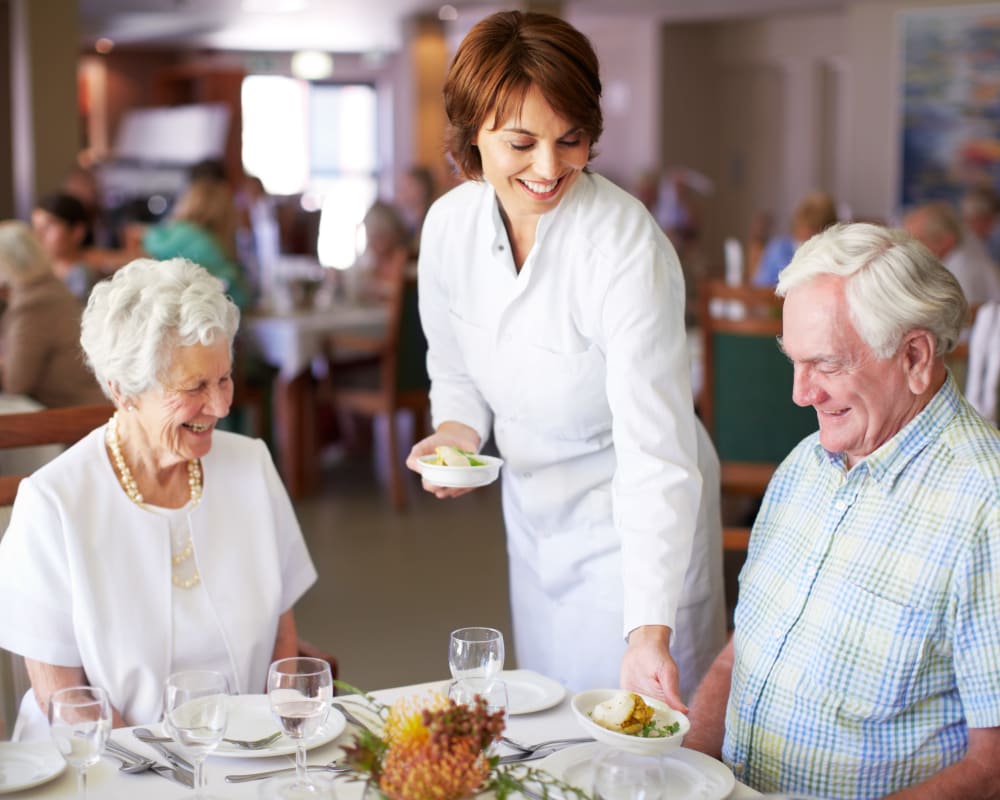 Two residents being served a meal at Welbrook Grand Montecito in Las Vegas, Nevada