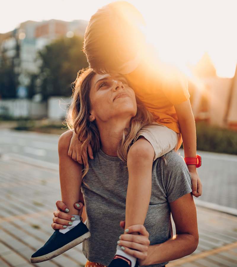 A mother carrying her child in the sunset near Waters Edge in Sacramento, California