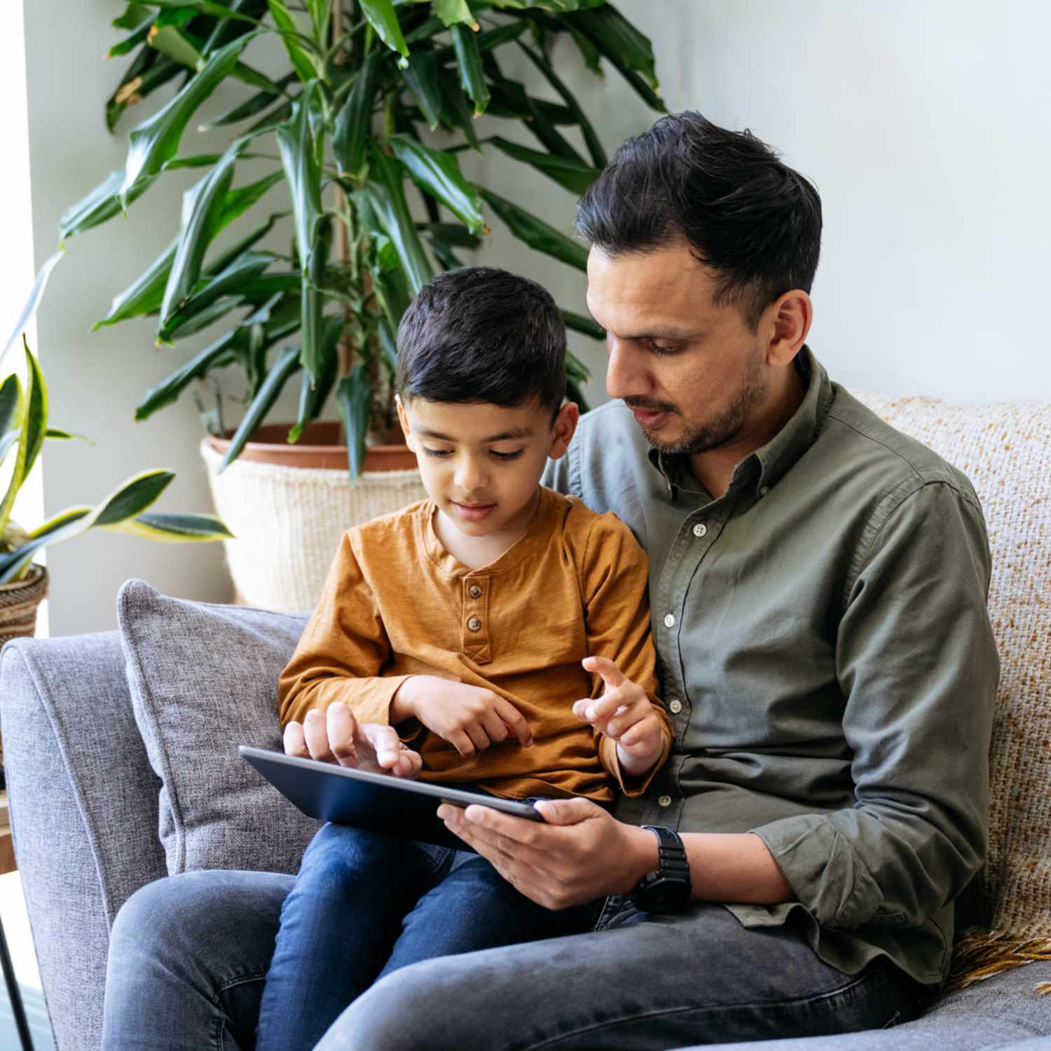 Resident spending time with his son in his living room at The Aberdeen in Oklahoma City, Oklahoma