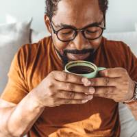 Smiling resident drinking coffee at 300 Optimist Park in Charlotte, North Carolina