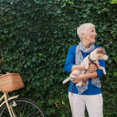 An old woman with a dog and a bicycle in a park at Village at Tradition in Port Saint Lucie, Florida