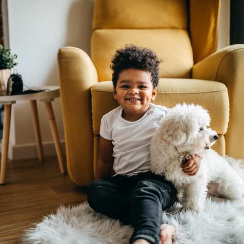 A child sitting with his dog in their apartment at Copper Stone in Lafayette, Colorado