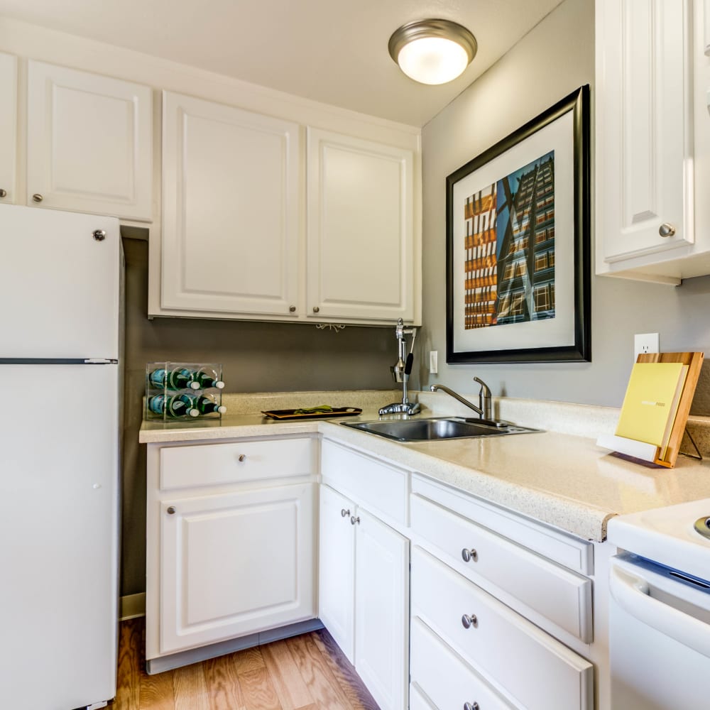 Modern kitchen with bright white appliances and matching cabinetry in a model home at The Landmark Apartment Homes in Sunnyvale, California