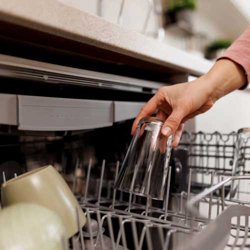 Resident loading the dishwasher at Schroeder Square Apartments in Madison, Wisconsin