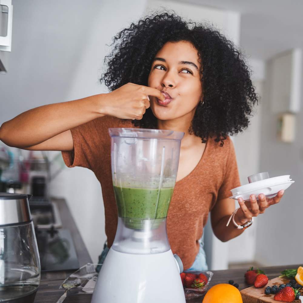 Woman tasting the food in her kitchen at Woodstock Square in Joshua, Texas