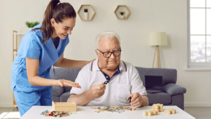 senior with puzzle being helped by caregiver.
