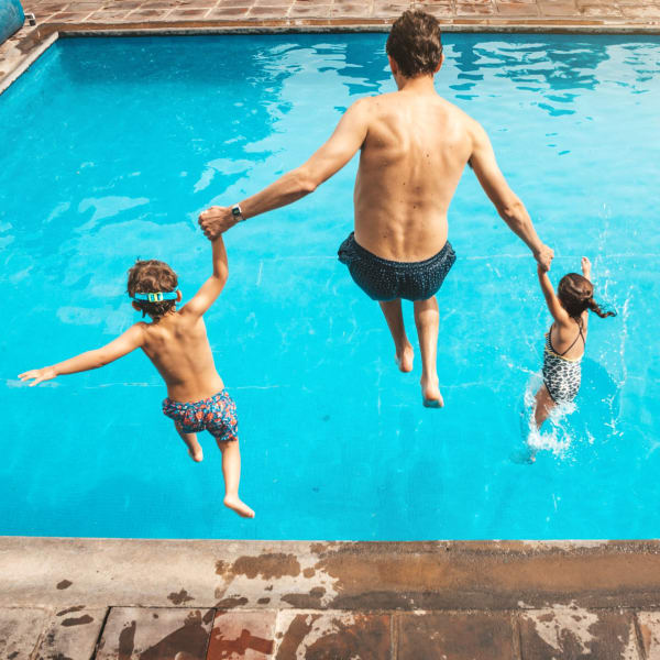 Father and two kids jumping into the swimming pool at Iron Horse Apartments in Stockton, California