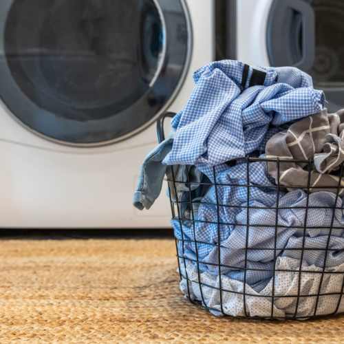 Washer and dryer with a basket of laundry at Shea Ravines in Wyoming, Michigan