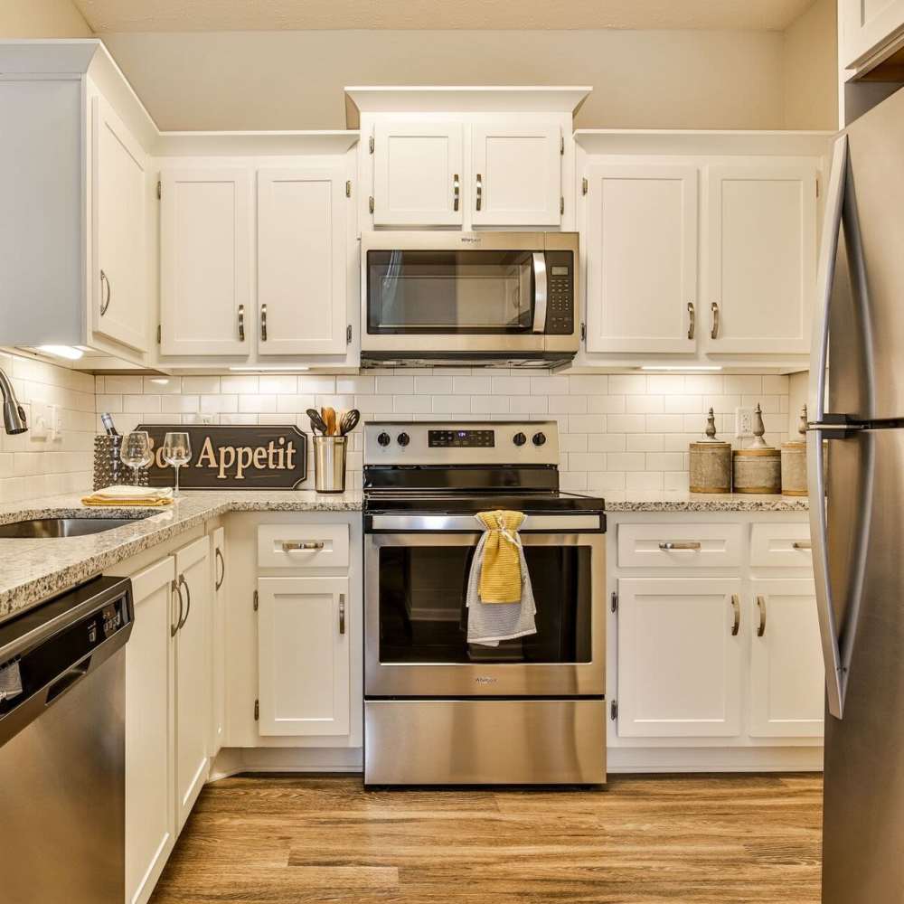 Model kitchen room with wood flooring and white cabinets at Avonlea Highlands in Cartersville, Georgia