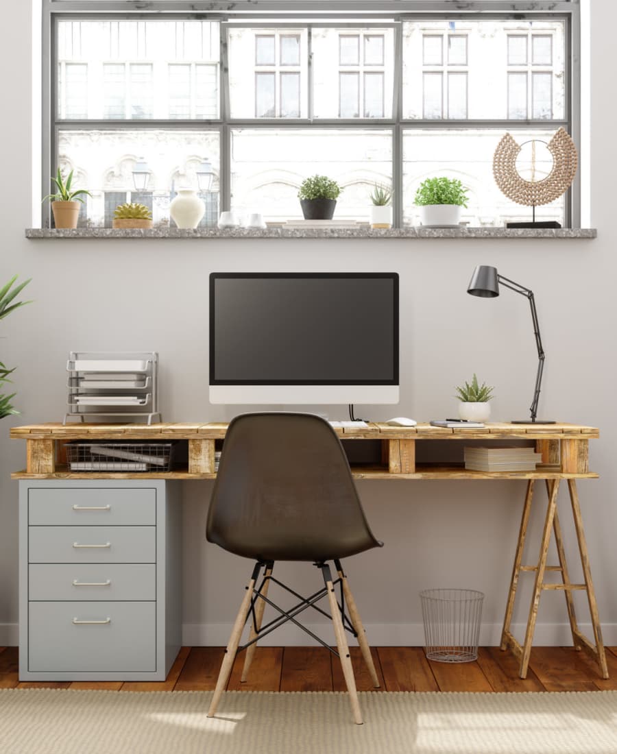 Modern workspace featuring a wooden desk, computer monitor, and stylish chair on wood-style flooring at Valley Brook Townhomes in Rochester, New York