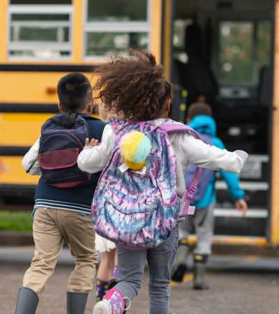 Kids getting on a school bus near Ventura Park Plaza Apartments in Portland, Oregon