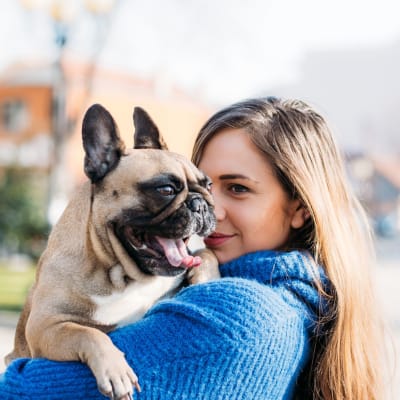 A woman holding her dog at Reagan Park in Lemoore, California
