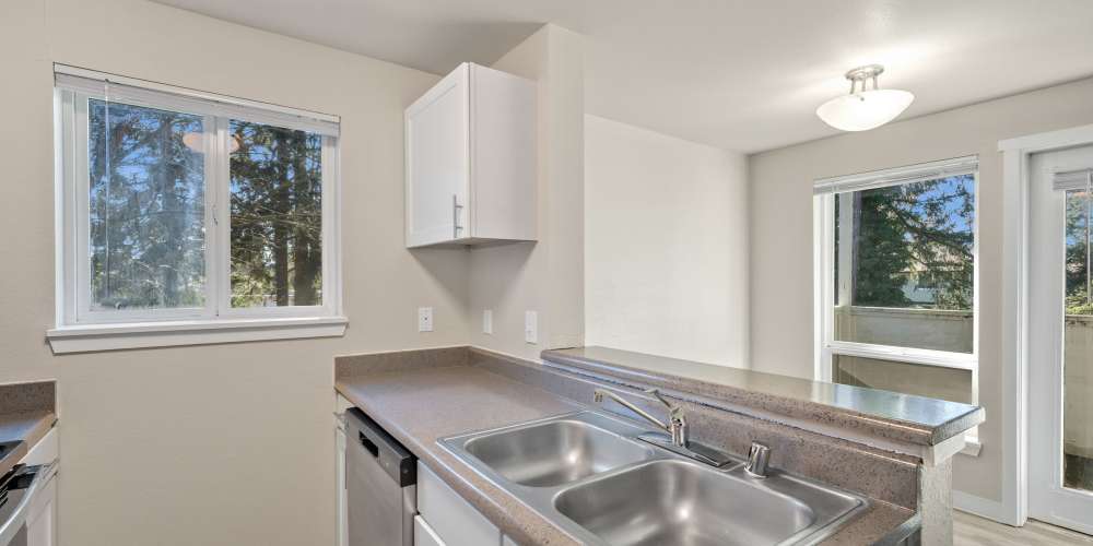 Modern dining area with four seater dining table and access to private patio at Briarstone in Tacoma, Washington