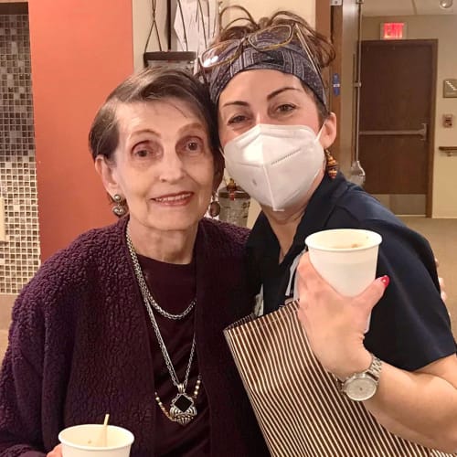 A masked team member with a resident at The Oxford Grand Assisted Living & Memory Care in McKinney, Texas