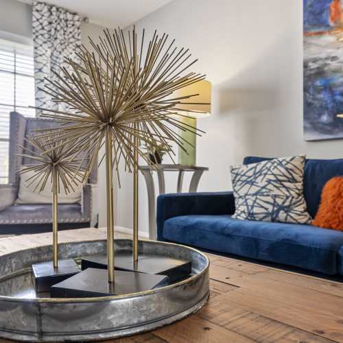 Patio and balcony access through a glass windowed door from an open-layout living room with hard-wood style flooring at Lockwood Heights in Richardson, Texas, 