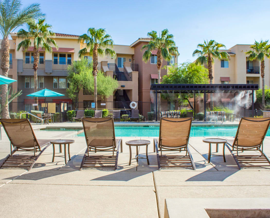 Chaise lounge chairs next to the pool at The Residences at Stadium Village in Surprise, Arizona