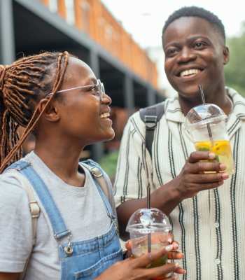 Two people holding drinks and smiling at Ardmore & Twenty Eighth in Atlanta, Georgia 