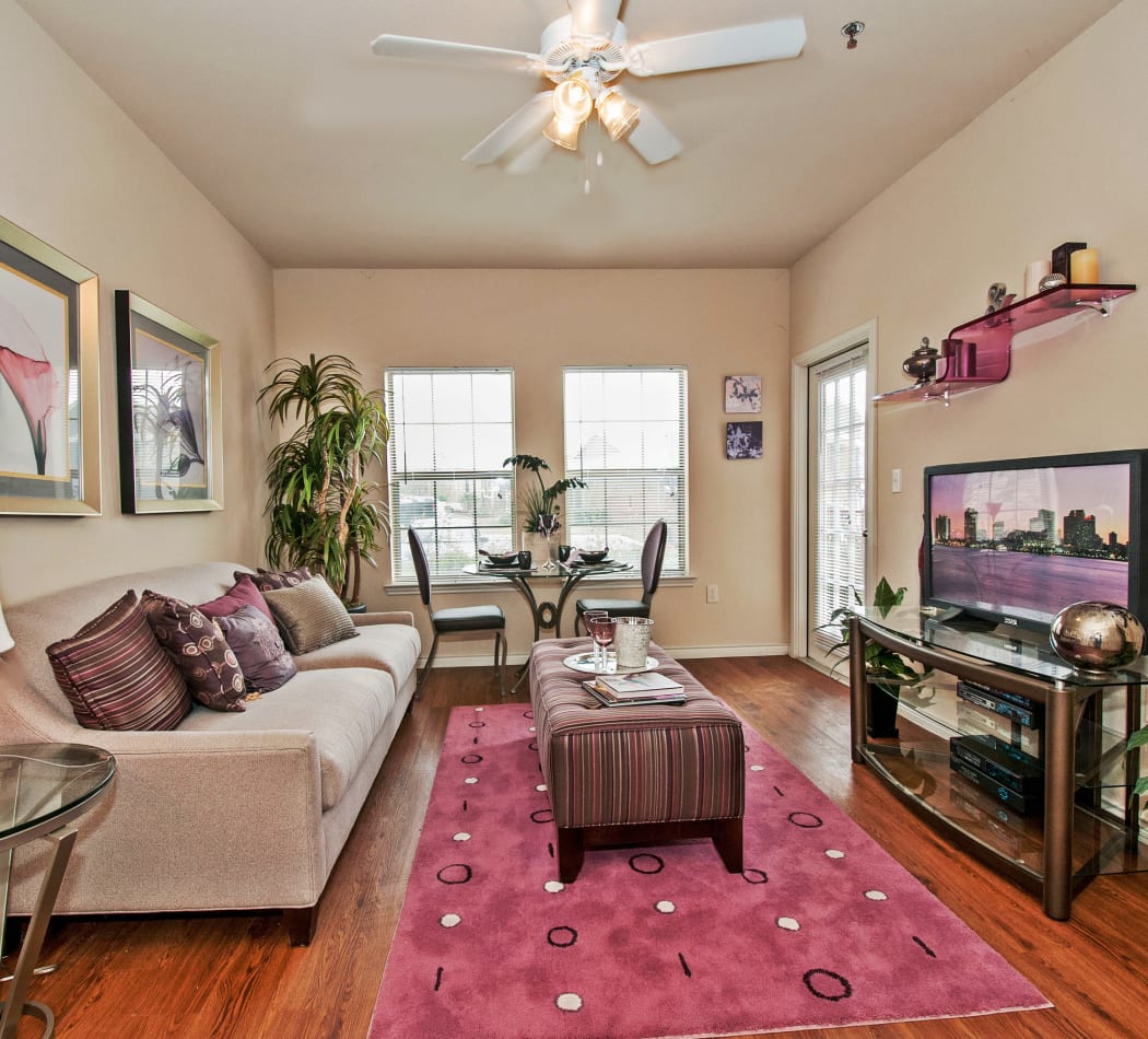 Open-concept living area with ceiling fan and hardwood floors in model home at Trails at Buda Ranch in Buda, Texas