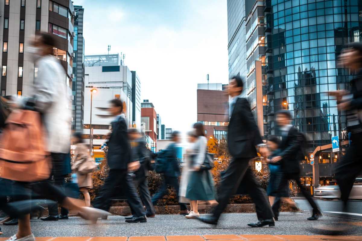 People walking through a busy intersection near Grand Peaks in Denver, Colorado