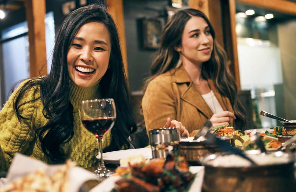 Friends enjoying a meal together, creating a warm and joyful atmosphere at nearby restaurant at Countryside Apartments in Poway, California