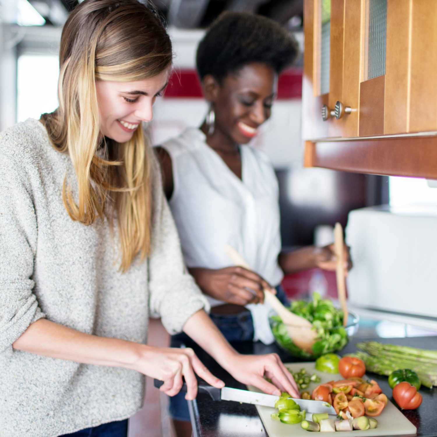 Resident couple cooking a meal together in their new home at Cambridge Apartments in Athens, Georgia