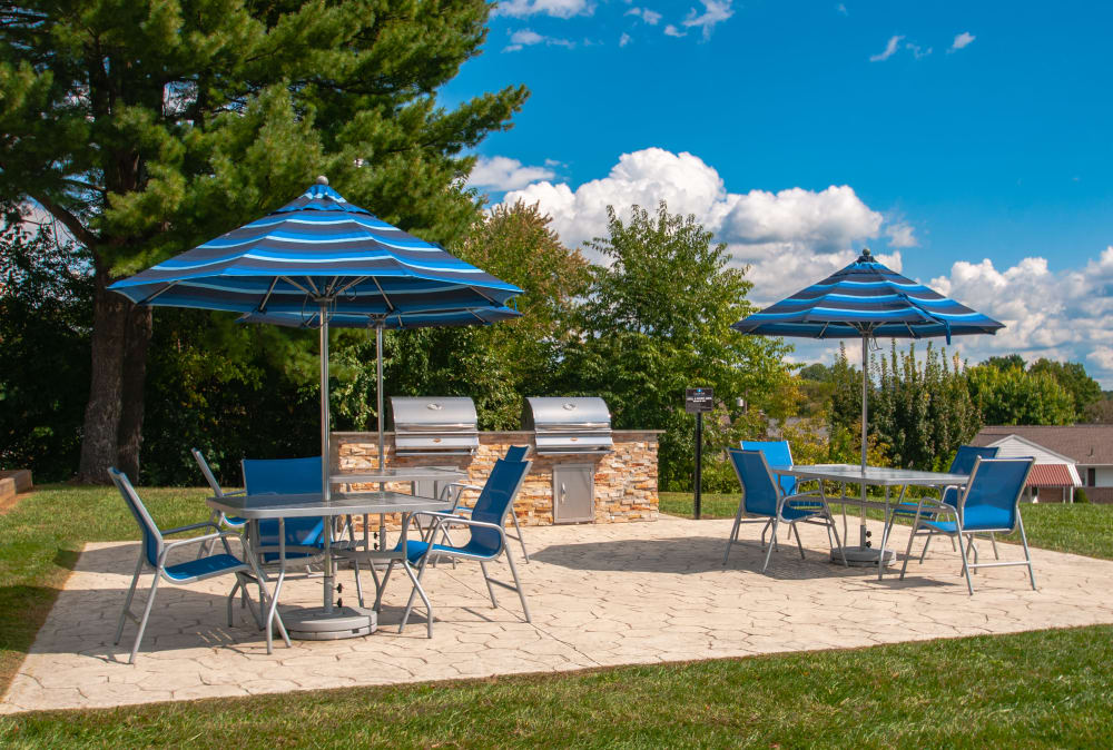 Outdoor grilling stations with seating at Lincoln Park Apartments & Townhomes in West Lawn, PA