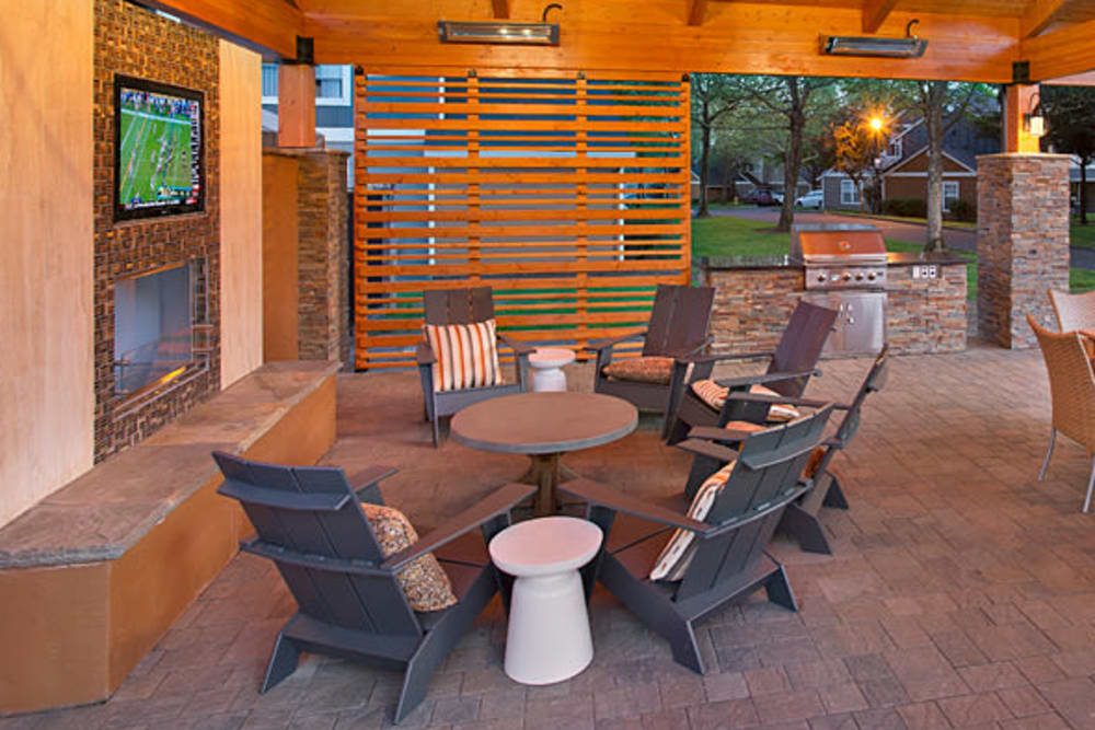 Lounge chairs under the cabana with a flat-screen TV at Slate Ridge at Fisher's Landing Apartment Homes in Vancouver, Washington