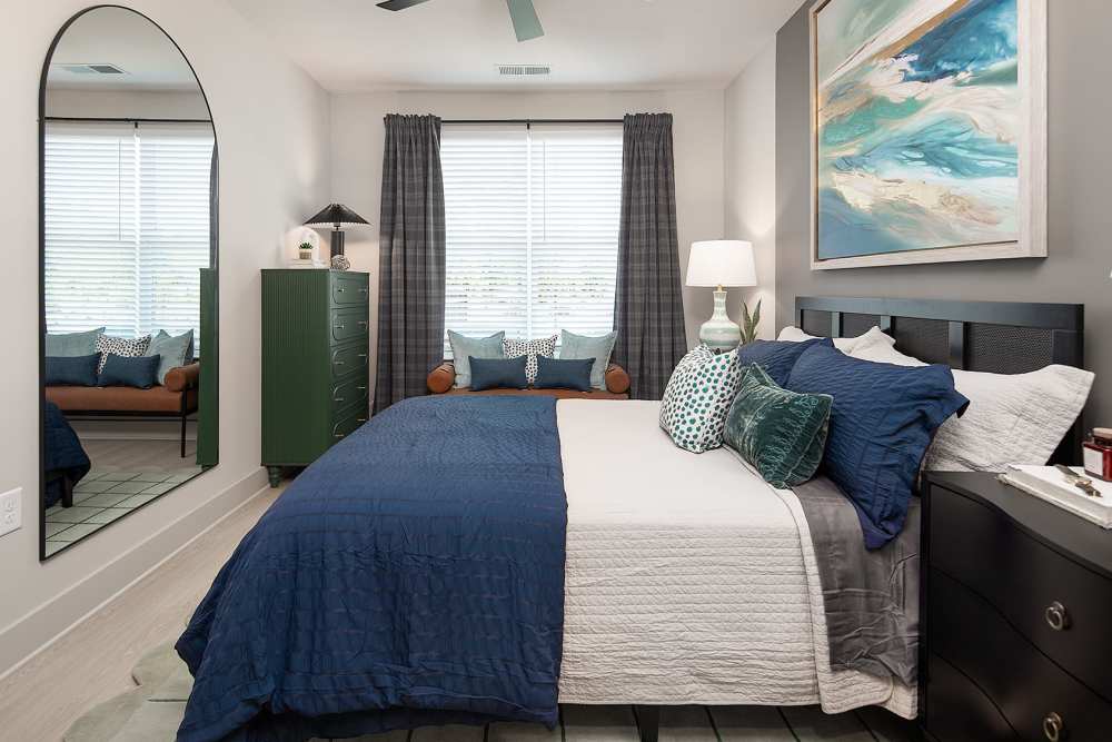 Bright luxury apartment bedroom with large windows, ceiling fan, and walk-in closet at Cypress Point Luxury Apartments near Lake Norman