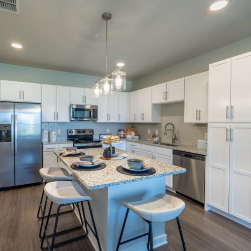 Stainless-steel appliances in a kitchen with an island at Indigo Champions Ridge in Davenport, Florida