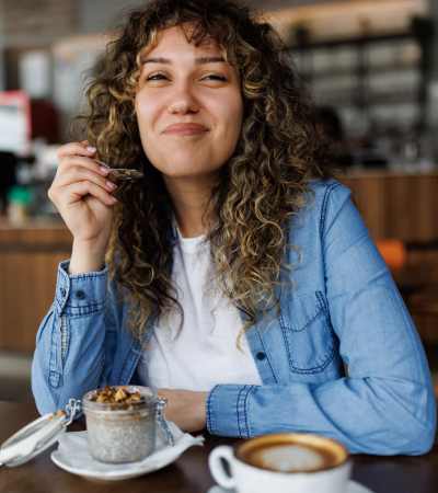 Resident enjoying dessert with coffee in a cozy café setting near Dutch Village Apartments in Baltimore, Maryland