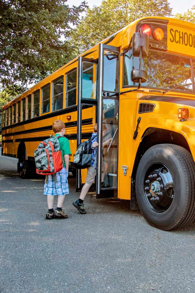 Residents children boarding school bus near Avalon II Apartments in Charleston, South Carolina
