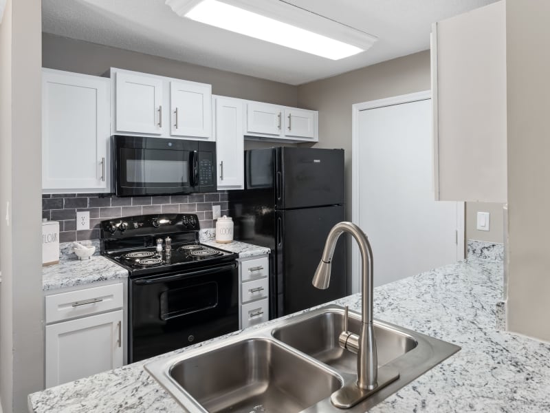 A kitchen with black appliances in a model apartment at Gates at Jubilee in Daphne, Alabama