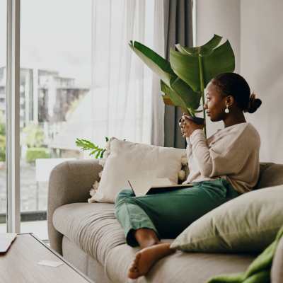 Resident woman having coffee in living room at The Retreat at Grande Lake, Brunswick, Georgia