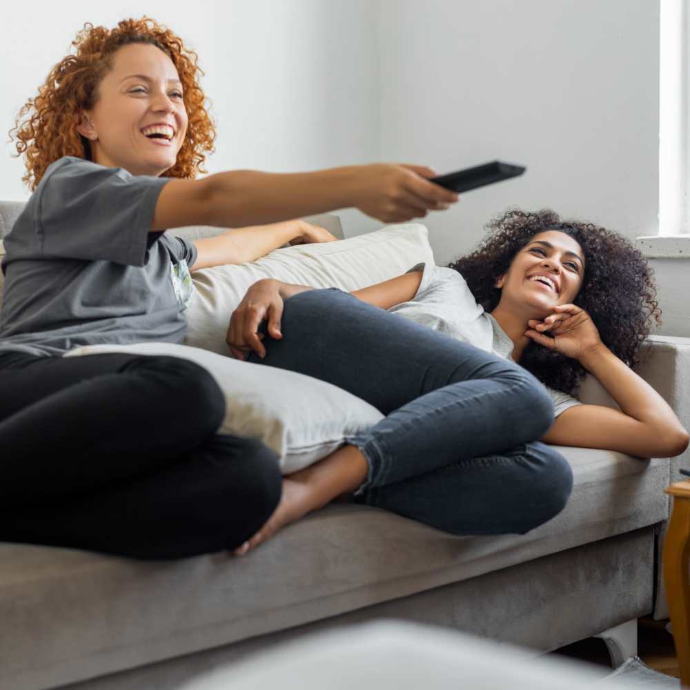 Residents relaxing on their comfortable couch at Trinity Buena Vista in Saint Charles, Michigan