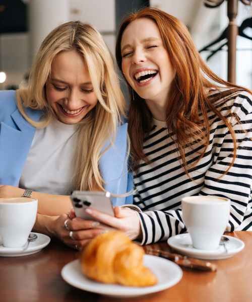 Two woman laughing at a table near The Village in Stratford, Connecticut