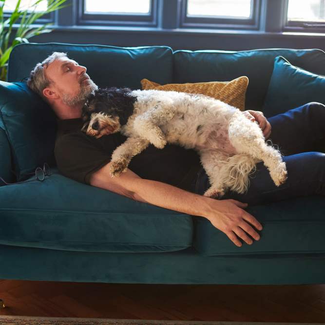 Resident relaxing with his dog on a couch at Vesta Creeks Run in North Charleston, South Carolina