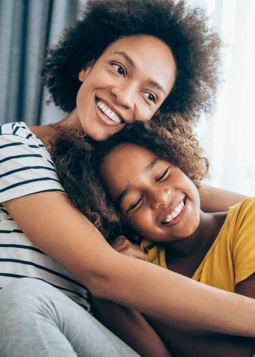 Resident woman hugging her daughter in a living room of a model apartment at Riverfront in Mount Holly, North Carolina
