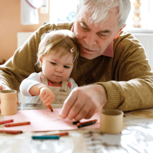 Resident painting with his young grandchild at Sunstone Village in Denton, Texas