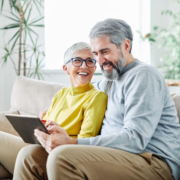A couple looking at a tablet at Pacifica Senior Living Sterling in Sterling, Virginia