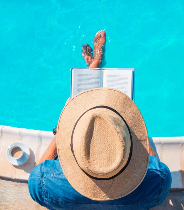 Resident relaxing on the edge of a swimming pool at The Kensley in Spanish Fort, Alabama