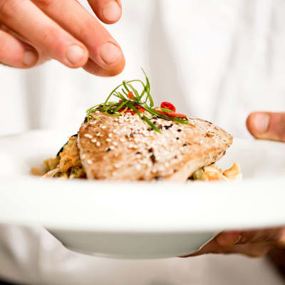 Chef topping off a meal at Cascade Park Gardens Memory Care in Tacoma, Washington