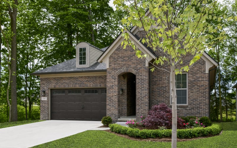 Cottage residence with a wide driveway and lush lawn at Blossom Ridge in Oakland Charter Township, Michigan