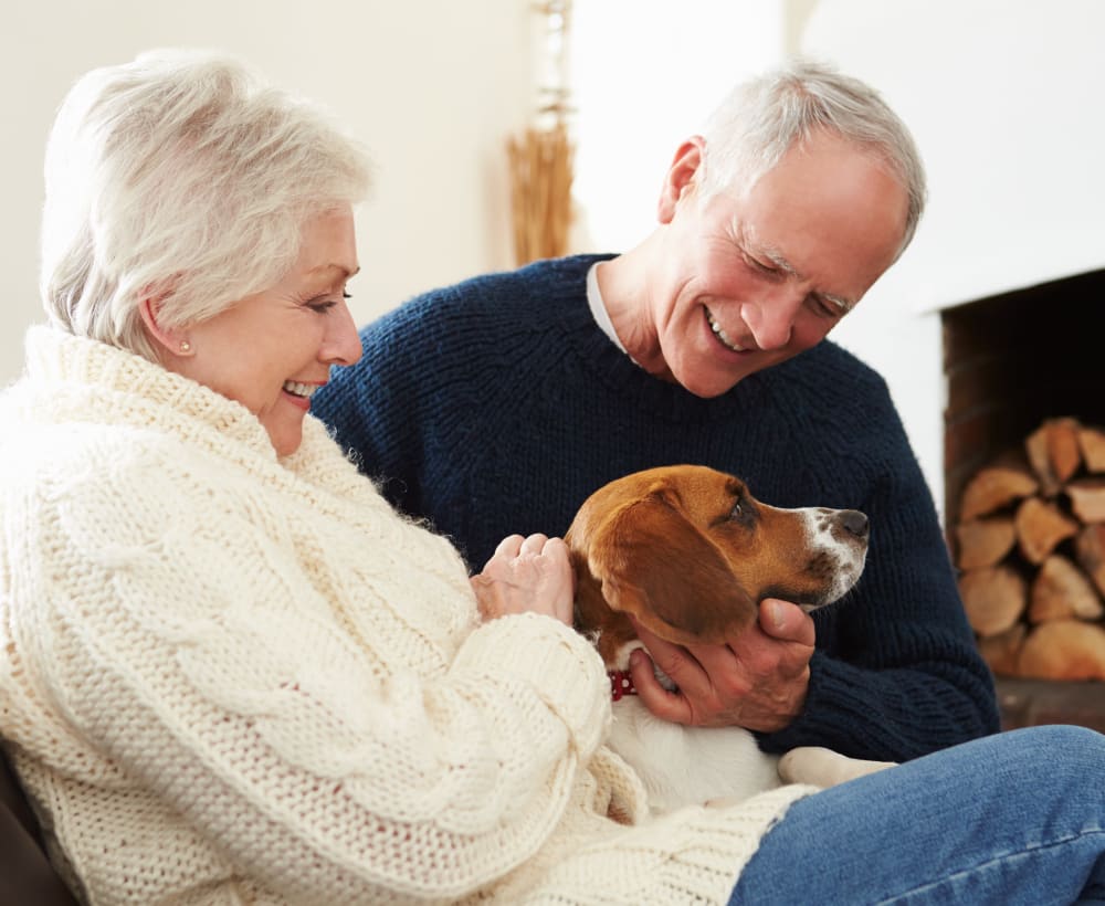 A couple from Touchmark on South Hill in Spokane, Washington petting their dog